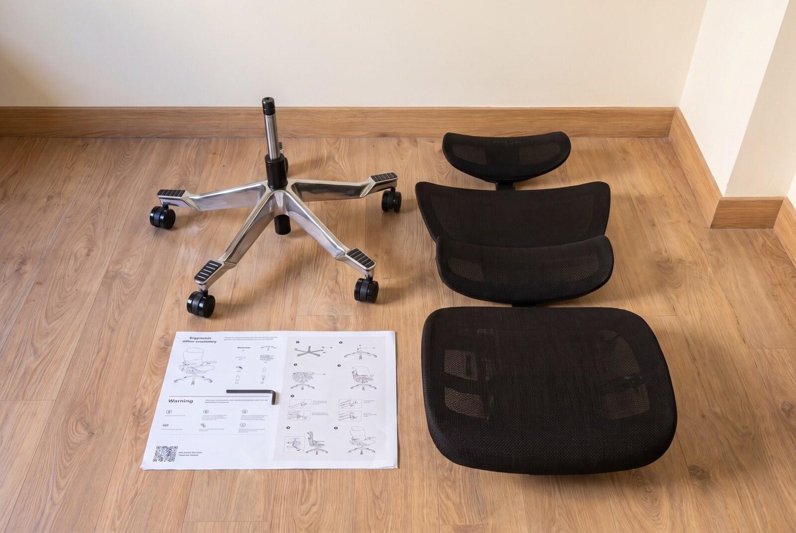 The Hinomi H2 Pro laid out in parts before assembly: base, backrest, headrest, seat and the instruction sheet